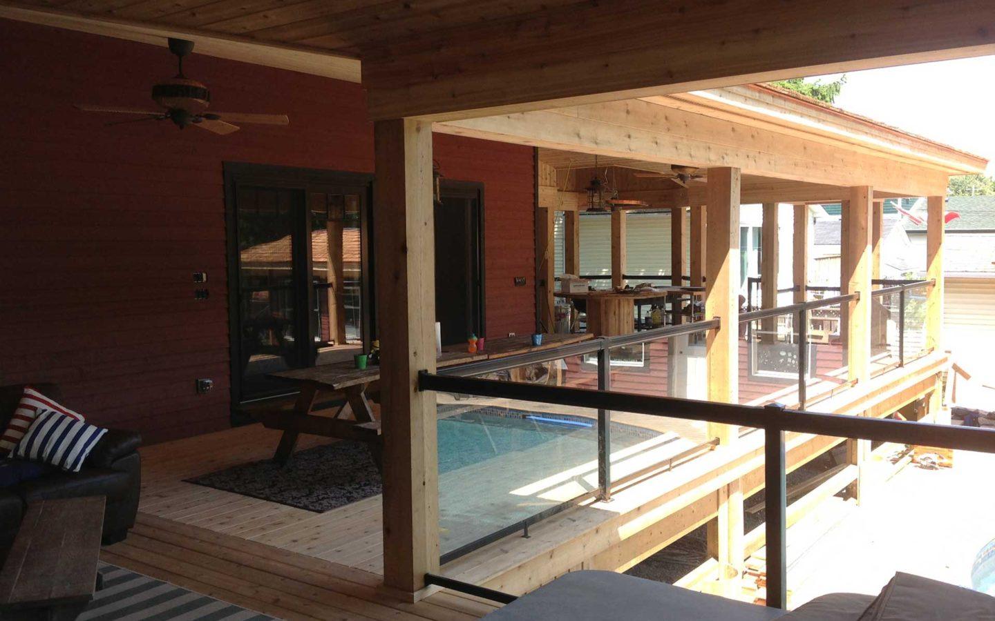 brown wooden house with glass fenced patio