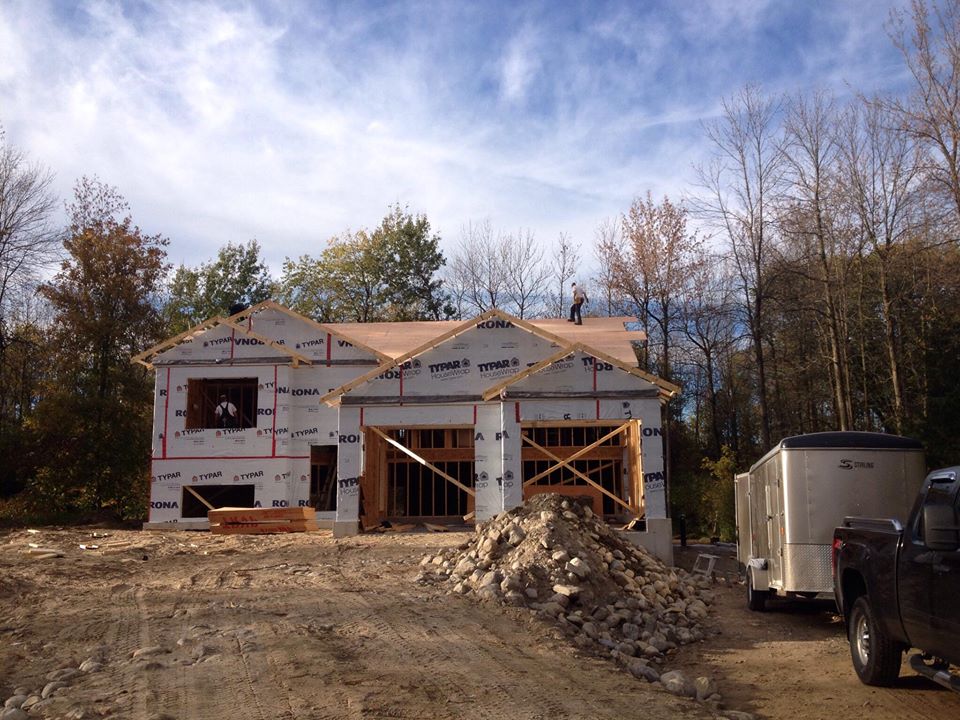 white and brown wooden house near bare trees under white clouds and blue sky during daytime