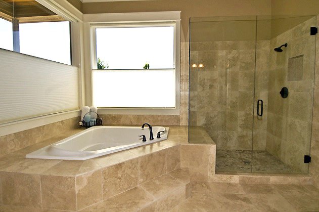 white ceramic bathroom with soaking tub and glassed in shower