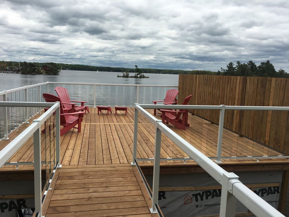 four red deck chairs overlooking a lake