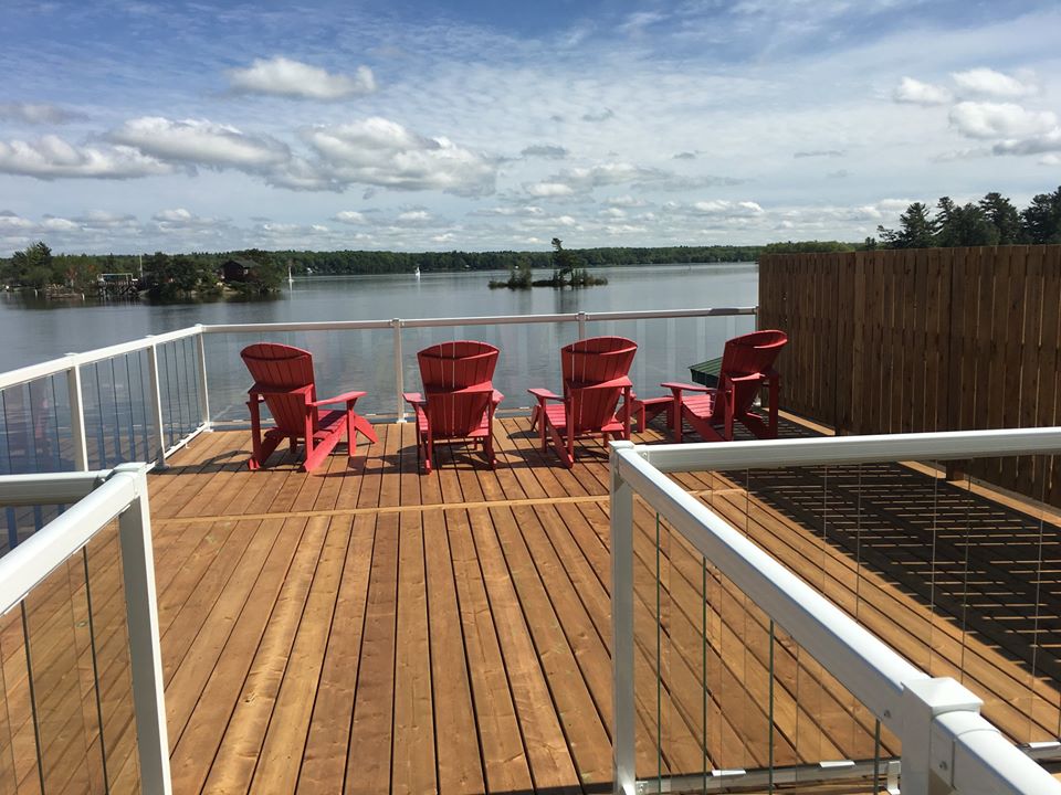 four red deck chairs overlooking a lake