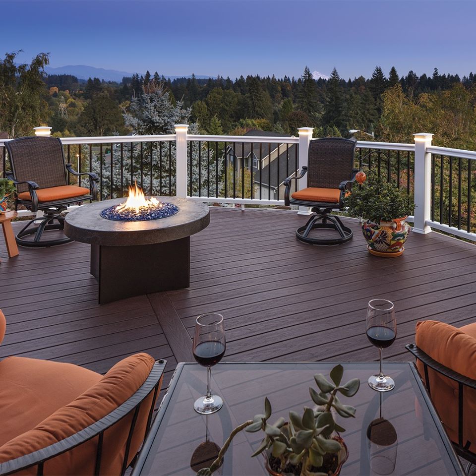 a fire pit with two deck chairs on an outdoor patio