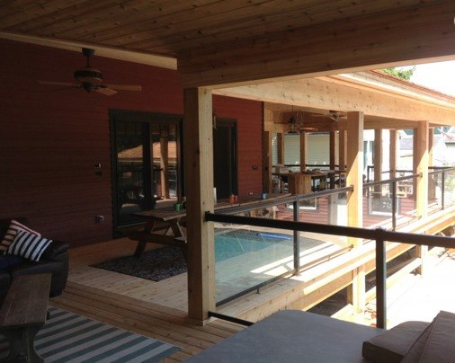 brown wooden house with glass fenced patio