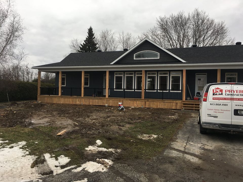 exterior photo of a one story home with blue siding and a front porch