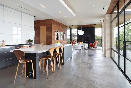 a large open concept kitchen with a concrete kitchen island and concrete floors