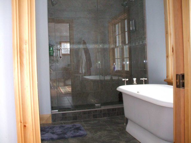 white soaking tub in a bathroom with glass shower doors